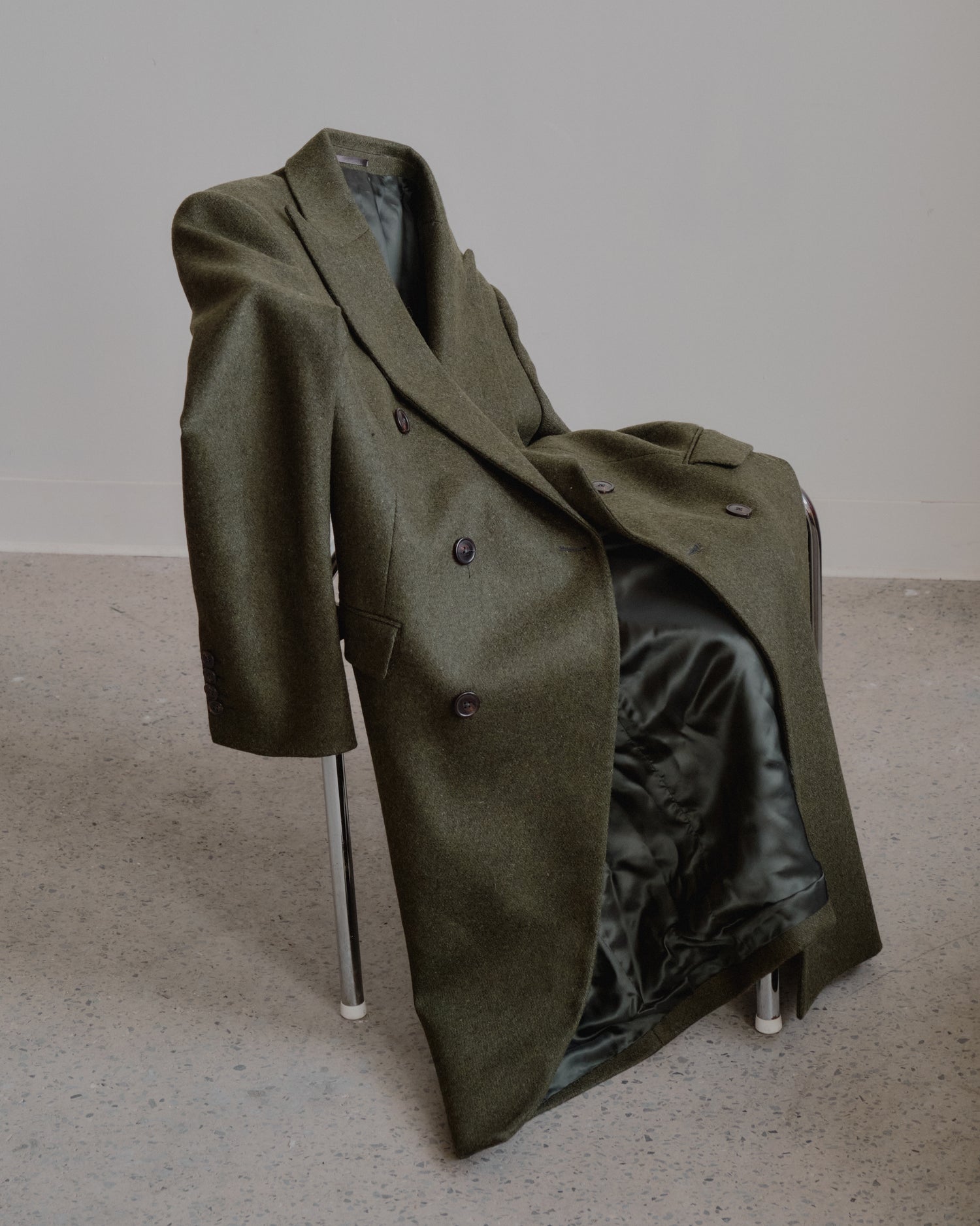 Green coat draped on a chair